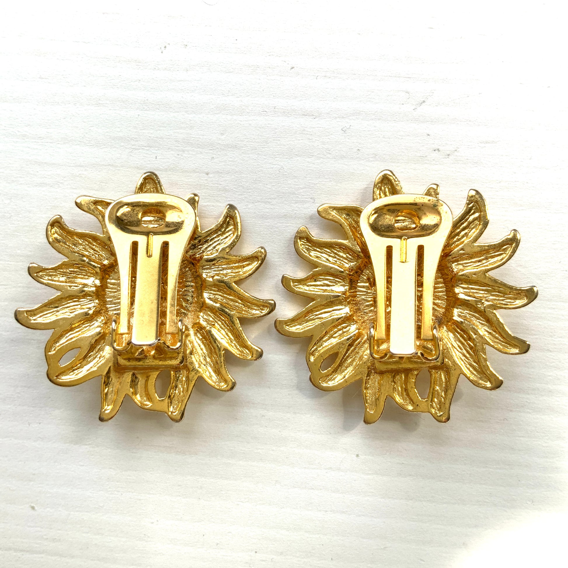 A charming pair of vintage Versace clip-on earrings featuring a gently smiling sun. 穏やかな微笑みをたたえた太陽の、ヴェルサーチのヴィンテージクリップイヤリング。