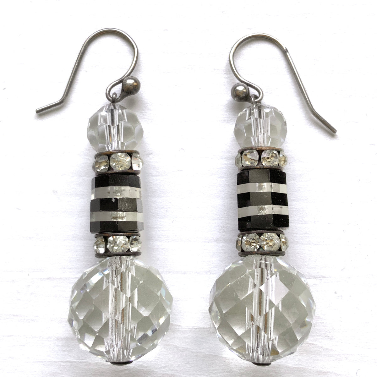 Art Deco vintage earrings featuring large faceted glass beads, striped black and clear glass elements, and sparkling rhinestone-set spacers. アールデコのヴィンテージピアス。