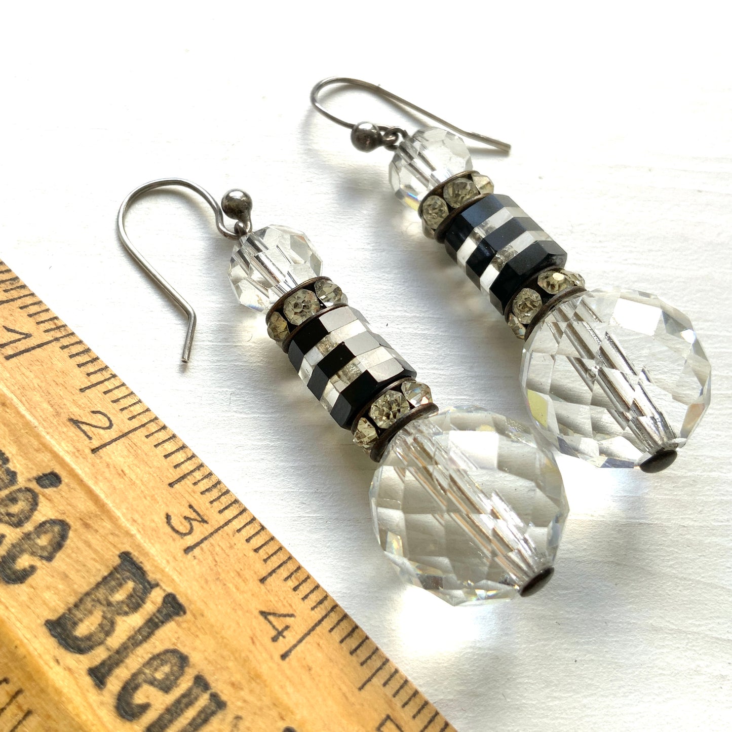 Art Deco vintage earrings featuring large faceted glass beads, striped black and clear glass elements, and sparkling rhinestone-set spacers. アールデコのヴィンテージピアス。