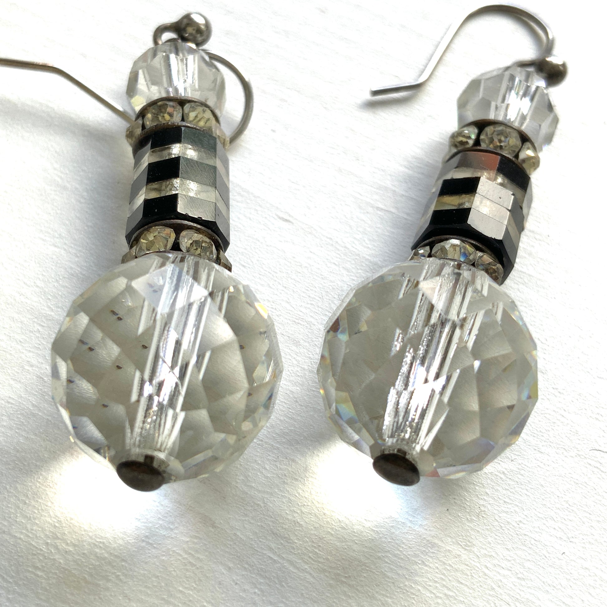 Art Deco vintage earrings featuring large faceted glass beads, striped black and clear glass elements, and sparkling rhinestone-set spacers. アールデコのヴィンテージピアス。