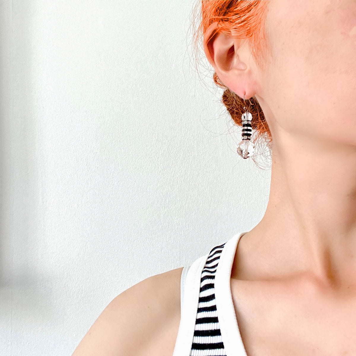 Art Deco vintage earrings featuring large faceted glass beads, striped black and clear glass elements, and sparkling rhinestone-set spacers. アールデコのヴィンテージピアス。
