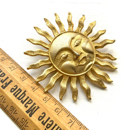 A charming vintage sun brooch featuring a smiling face.  笑顔をたたえた太陽のヴィンテージブローチ。