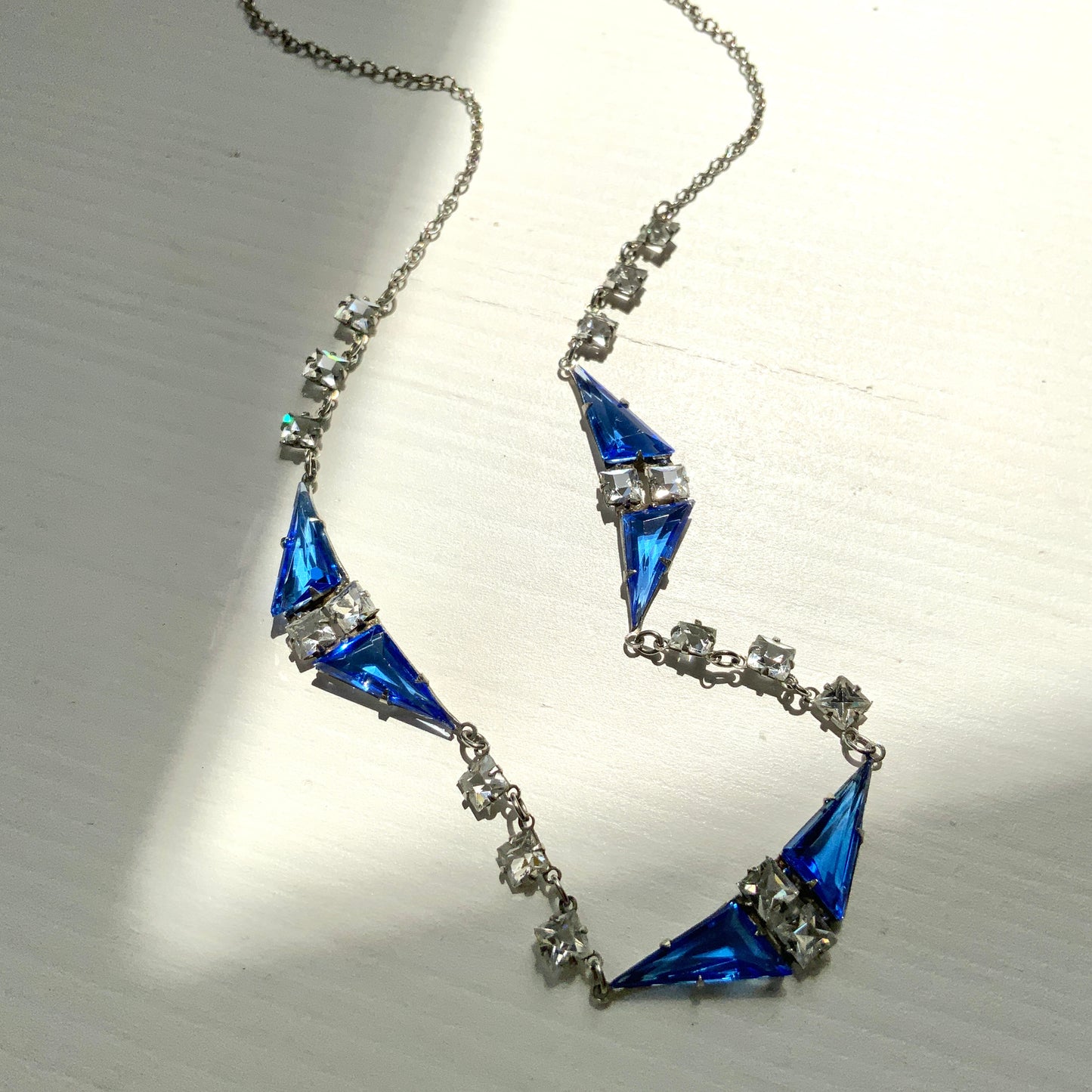 A vintage necklace from the Art Deco era, featuring vivid blue and clear glass stones.  鮮やかなブルーグラスとクリアグラスを組み合わせた、アールデコ時代のヴィンテージネックレス。