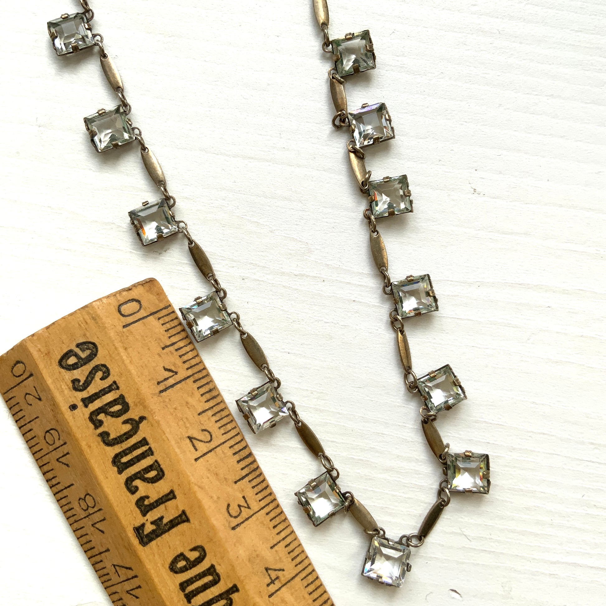 A classic Art Deco silver necklace set with square-cut clear glass stones. クラシックなスクエアカットのクリアグラスが並ぶ、アールデコのシルバーネックレス。