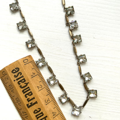 A classic Art Deco silver necklace set with square-cut clear glass stones. クラシックなスクエアカットのクリアグラスが並ぶ、アールデコのシルバーネックレス。
