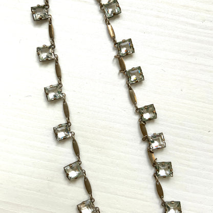 A classic Art Deco silver necklace set with square-cut clear glass stones. クラシックなスクエアカットのクリアグラスが並ぶ、アールデコのシルバーネックレス。