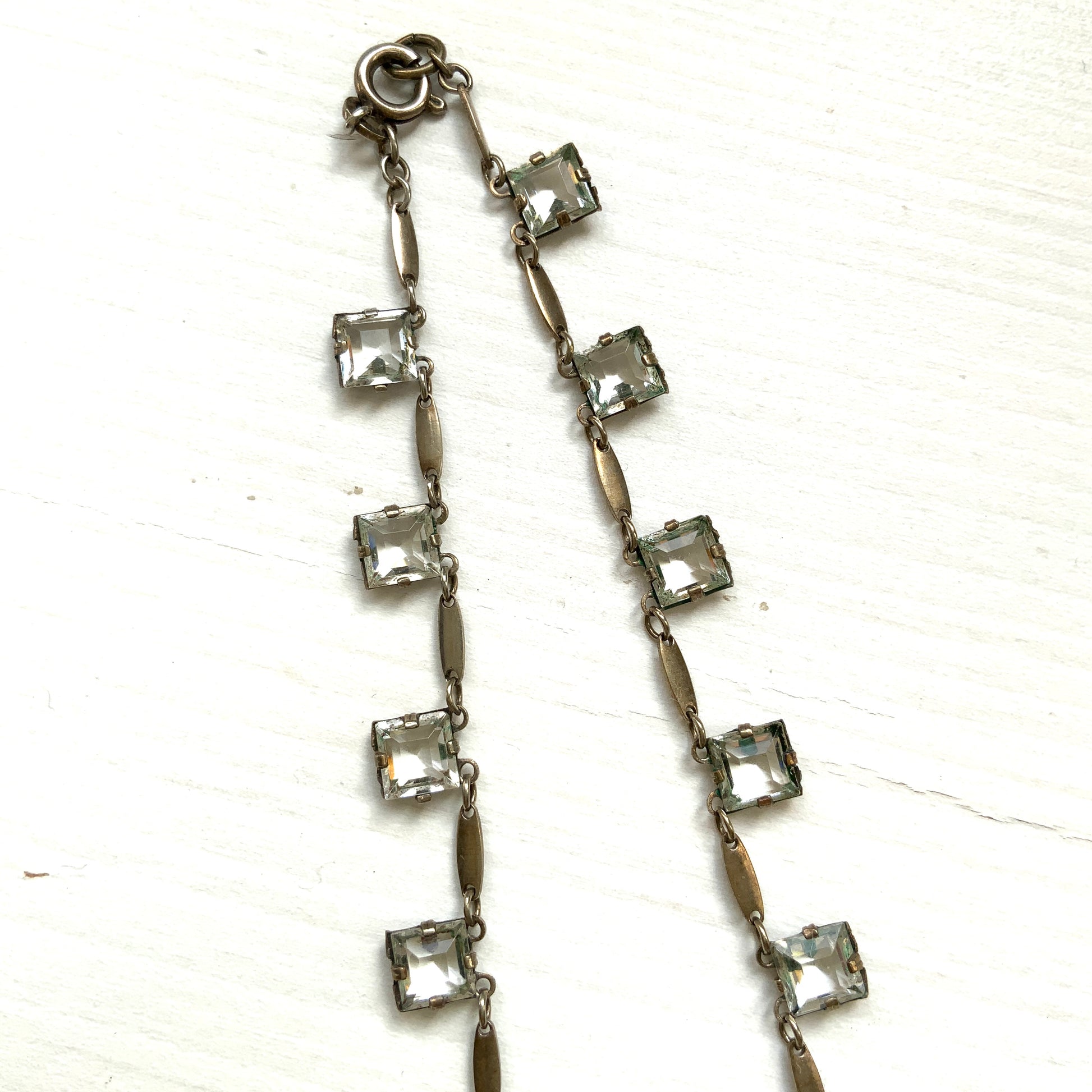 A classic Art Deco silver necklace set with square-cut clear glass stones. クラシックなスクエアカットのクリアグラスが並ぶ、アールデコのシルバーネックレス。