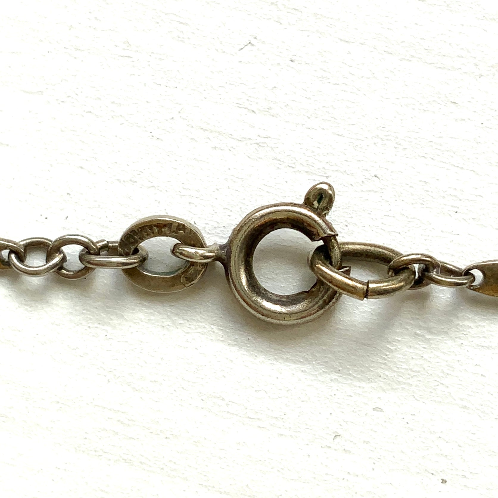 A classic Art Deco silver necklace set with square-cut clear glass stones. クラシックなスクエアカットのクリアグラスが並ぶ、アールデコのシルバーネックレス。