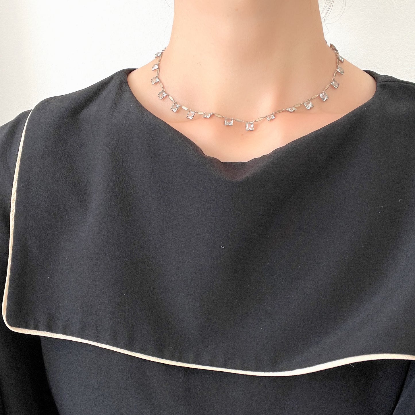 A classic Art Deco silver necklace set with square-cut clear glass stones. クラシックなスクエアカットのクリアグラスが並ぶ、アールデコのシルバーネックレス。