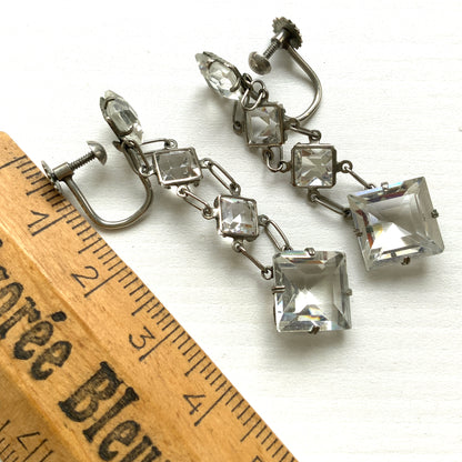 Screw-back earrings featuring clear diamond-shaped glass drops.クリアのダイヤ型グラスが揺れる、スクリューイヤリング。 