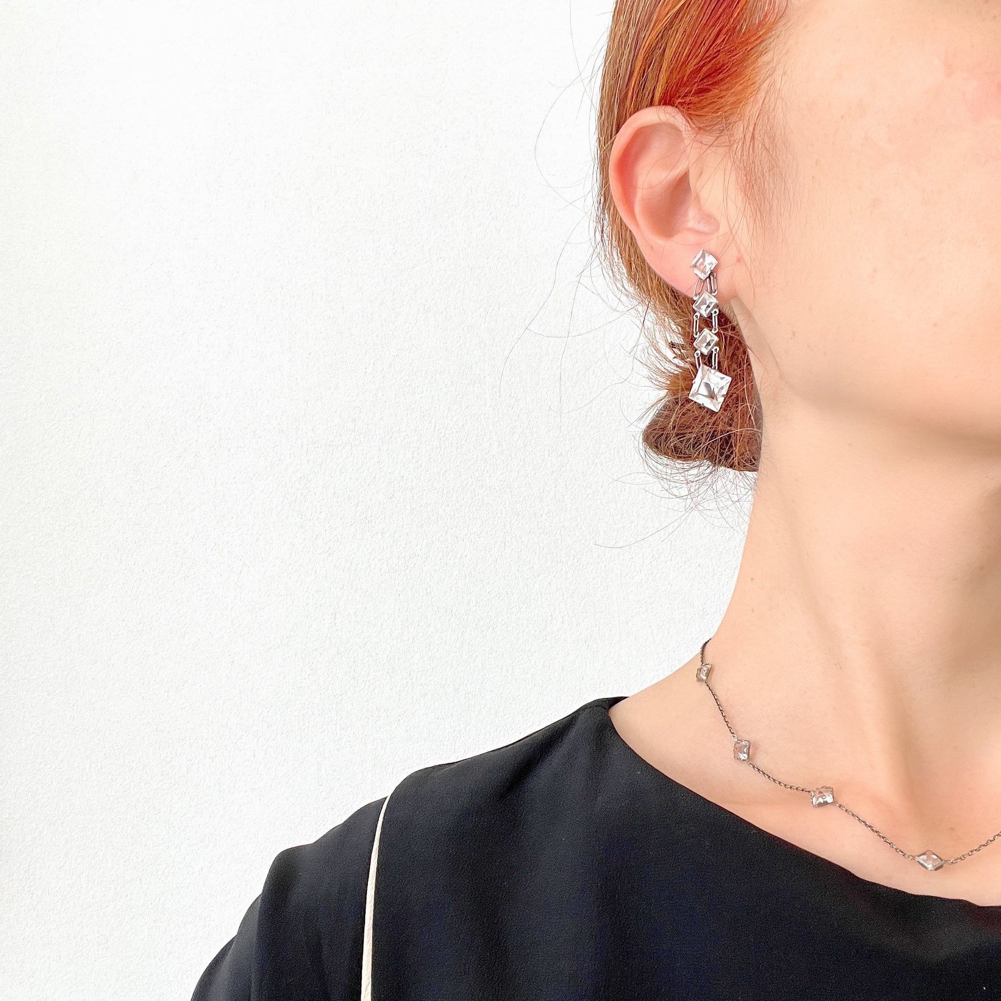 Screw-back earrings featuring clear diamond-shaped glass drops.クリアのダイヤ型グラスが揺れる、スクリューイヤリング。 