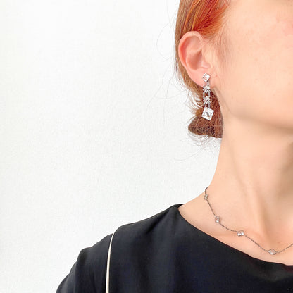 Screw-back earrings featuring clear diamond-shaped glass drops.クリアのダイヤ型グラスが揺れる、スクリューイヤリング。 