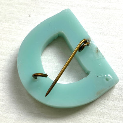 A brooch in the shape of the letter “D”, crafted from pale blue early plastic and adorned with colourful clay flowers. 淡い水色のアーリープラスチックに、カラフルなクレイのお花が咲いた”D"のブローチ。