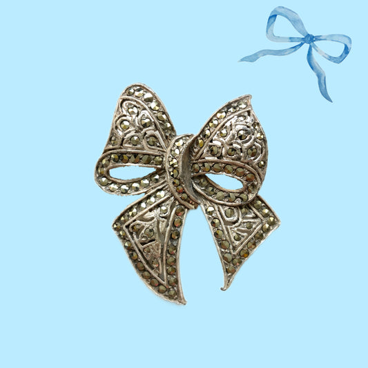 Silver-tone metal bow brooch set with marcasites. シルバートーンメタルにマーカサイトがあしらわれたリボンのブローチ。