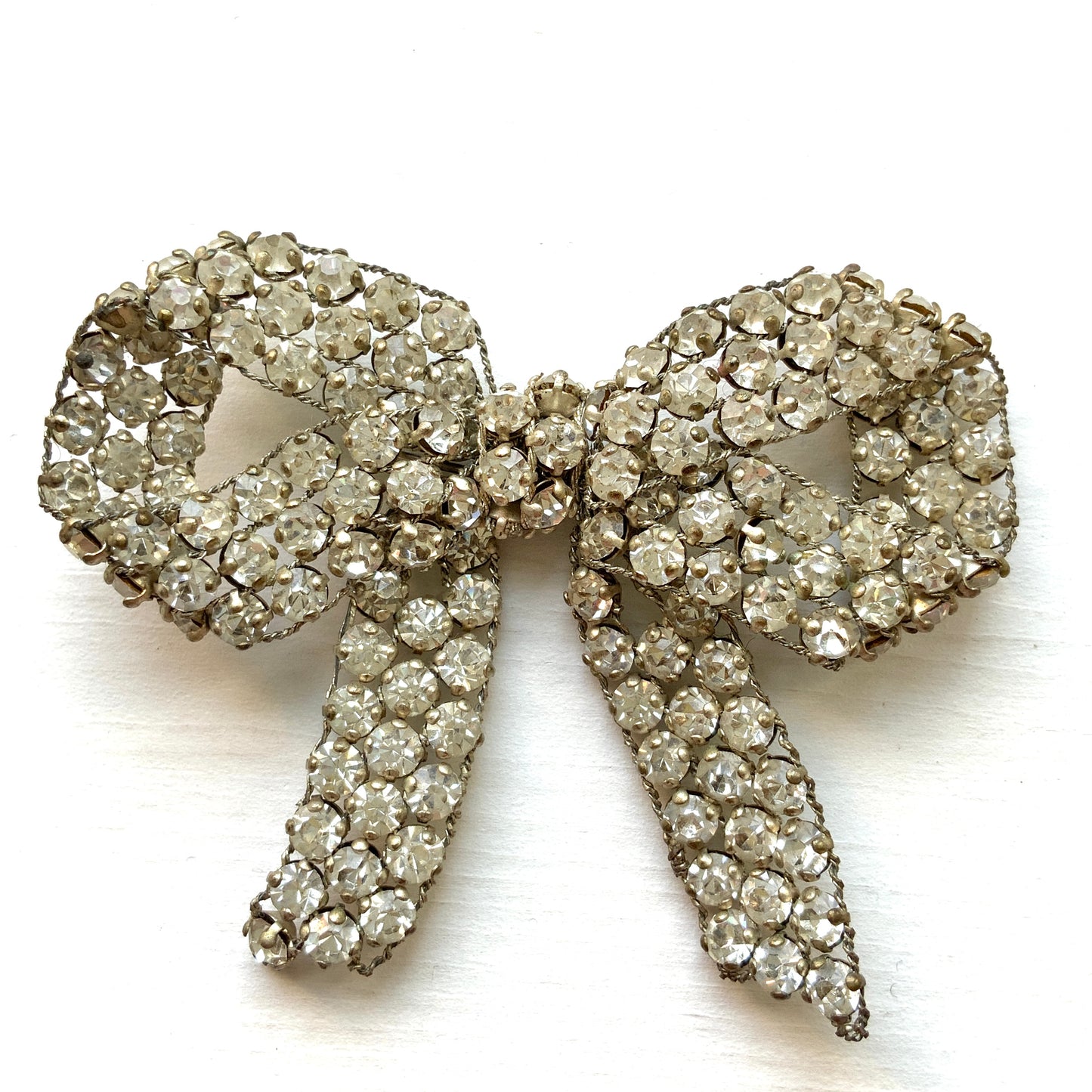 A wire bow brooch set with clear rhinestones. ラインストーンがあしらわれたワイヤーリボンのブローチ。