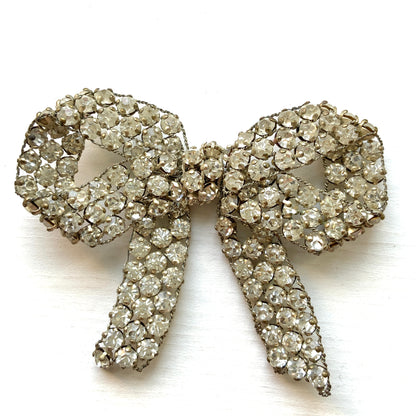 A wire bow brooch set with clear rhinestones. ラインストーンがあしらわれたワイヤーリボンのブローチ。