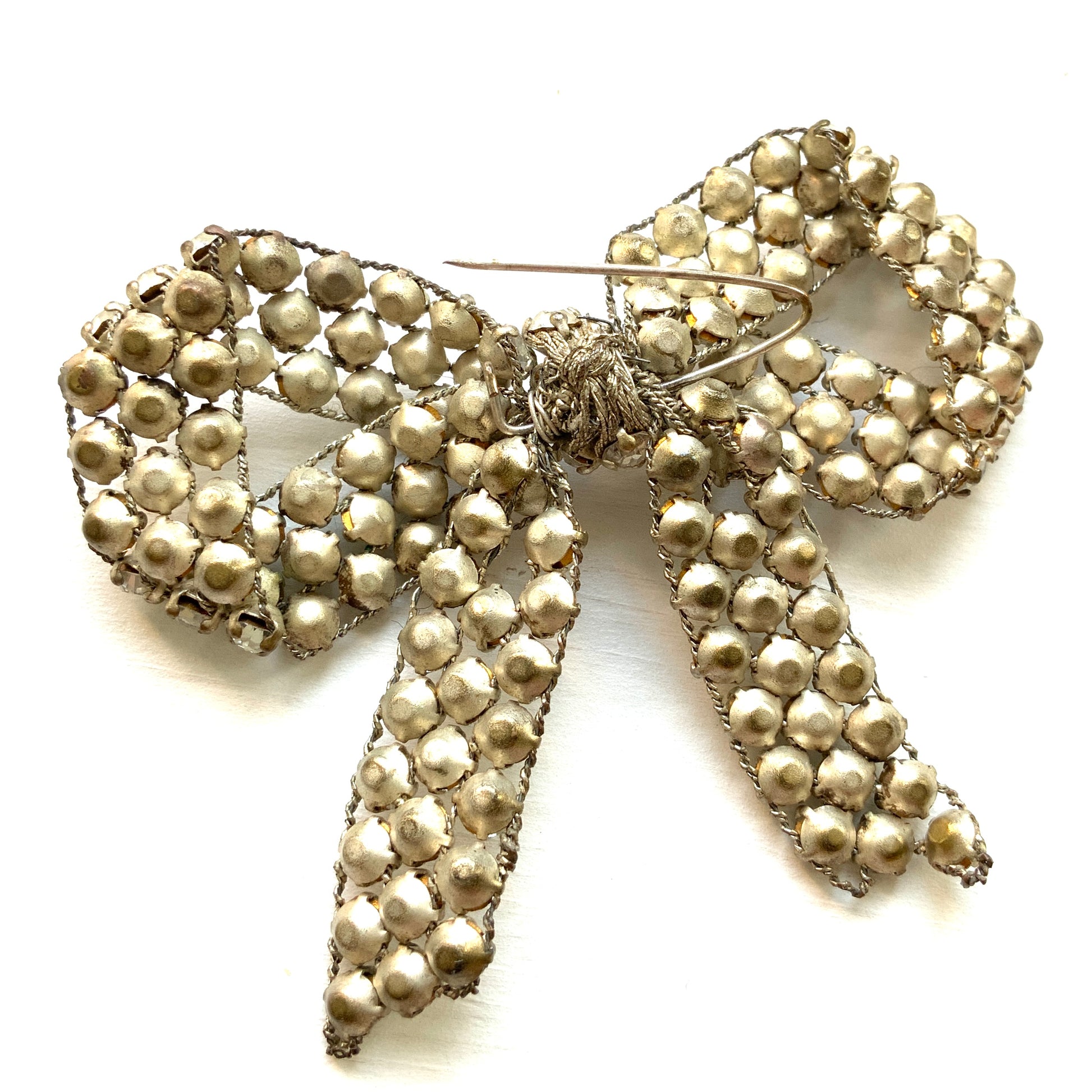 A wire bow brooch set with clear rhinestones. ラインストーンがあしらわれたワイヤーリボンのブローチ。