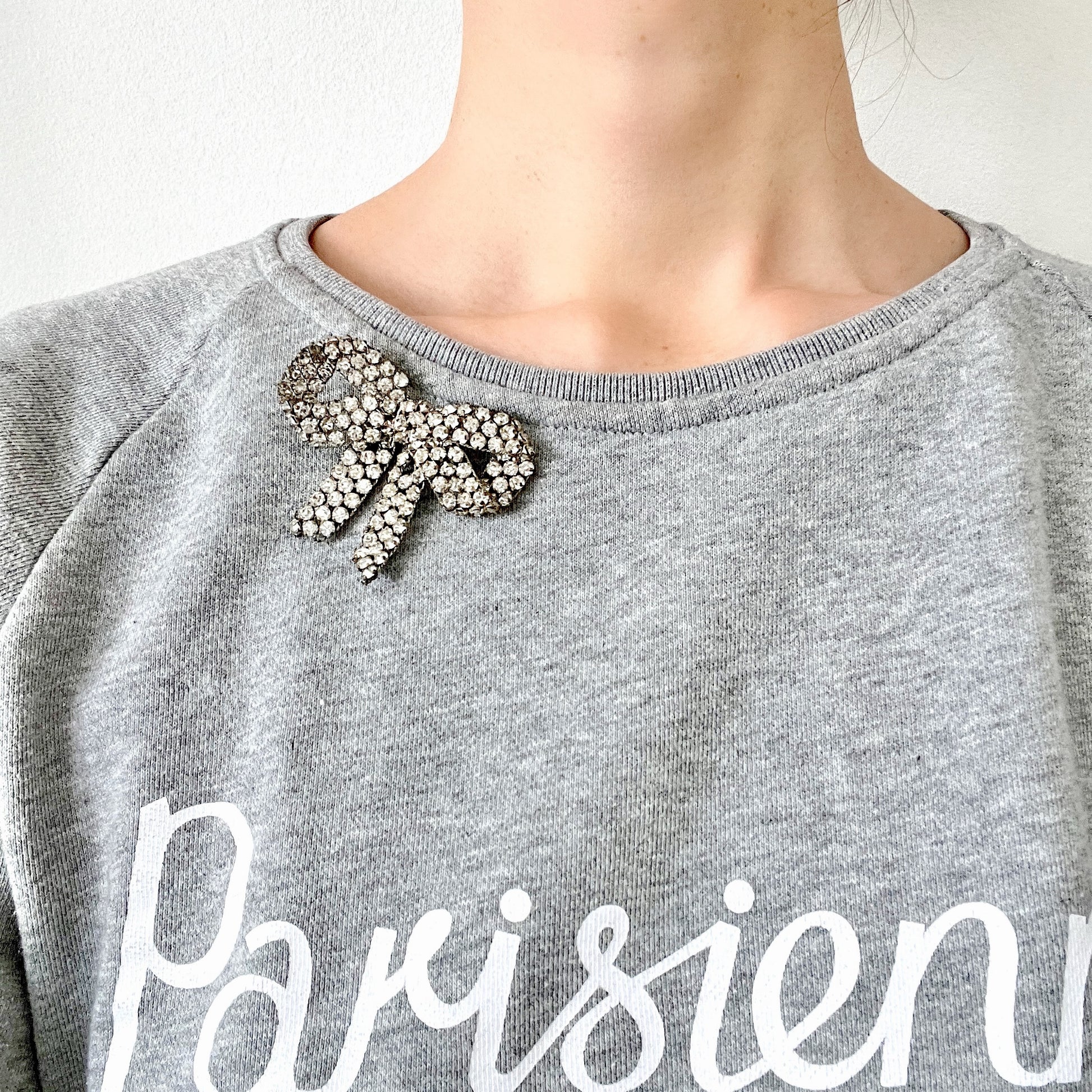 A wire bow brooch set with clear rhinestones. ラインストーンがあしらわれたワイヤーリボンのブローチ。