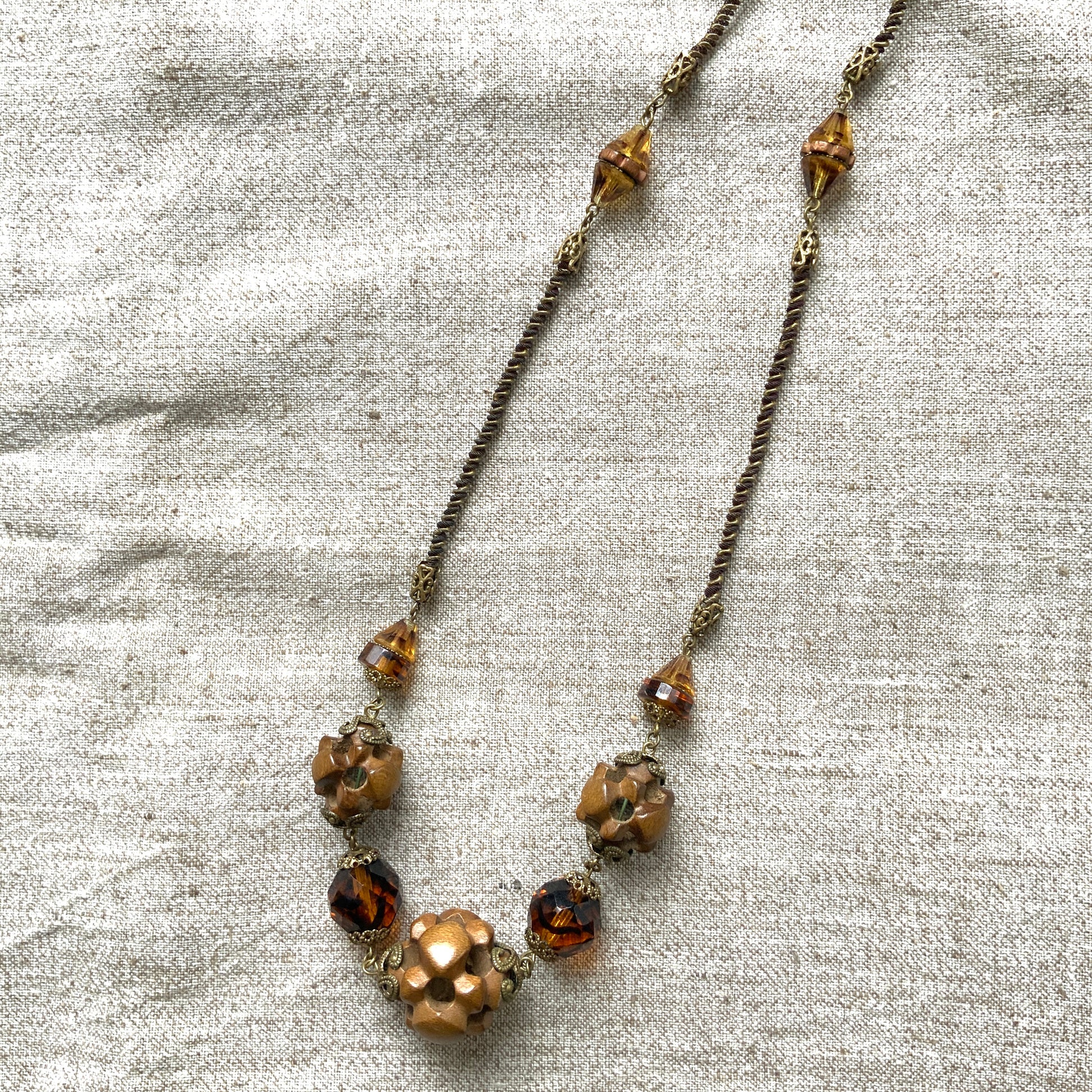 A striking necklace featuring unique wood beads and amber glass. 個性的なウッドビーズとアンバーグラスを組み合わせたネックレス。