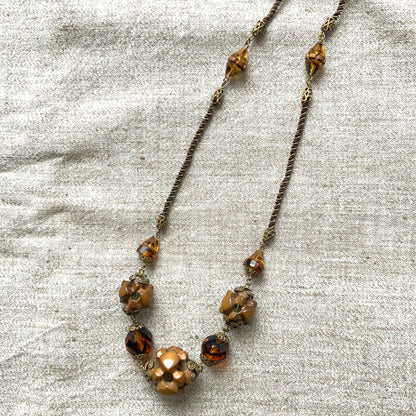 A striking necklace featuring unique wood beads and amber glass. 個性的なウッドビーズとアンバーグラスを組み合わせたネックレス。