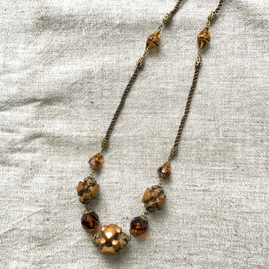 A striking necklace featuring unique wood beads and amber glass. 個性的なウッドビーズとアンバーグラスを組み合わせたネックレス。