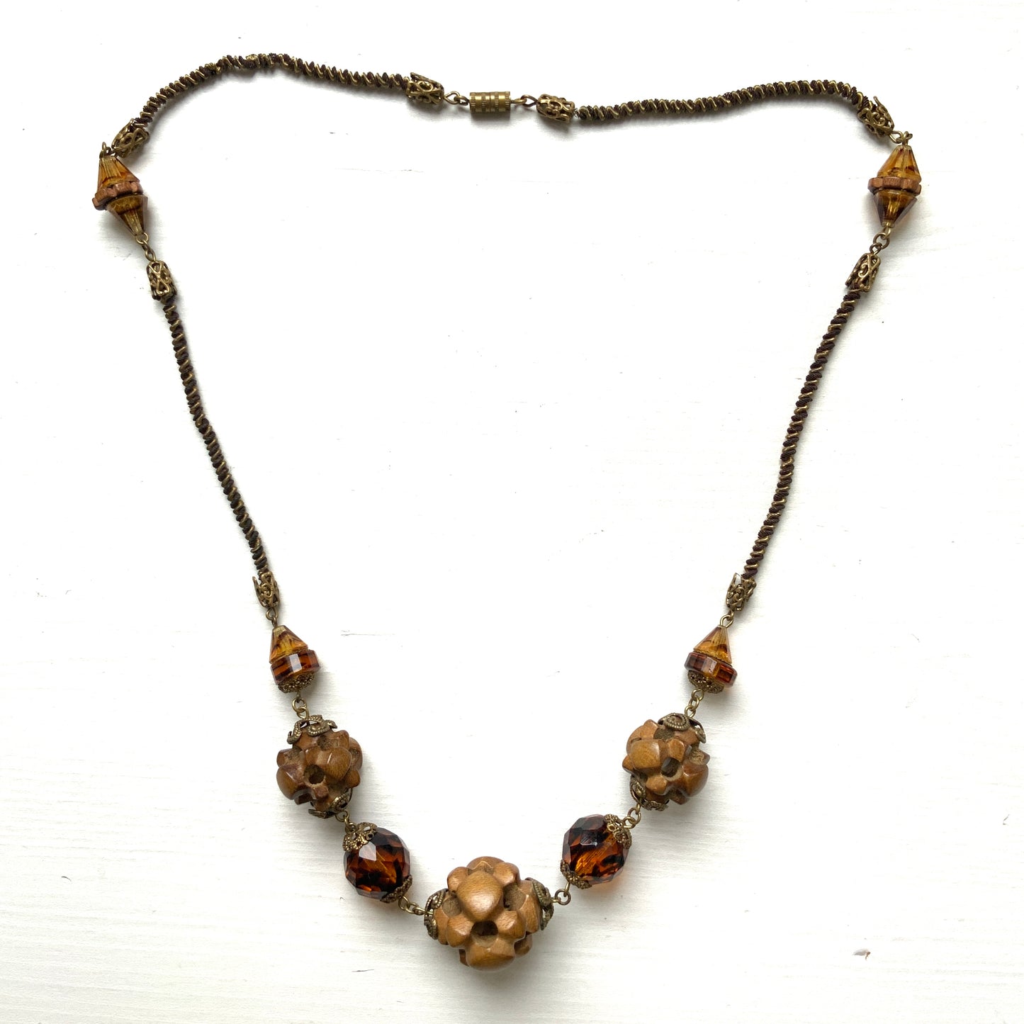 A striking necklace featuring unique wood beads and amber glass. 個性的なウッドビーズとアンバーグラスを組み合わせたネックレス。