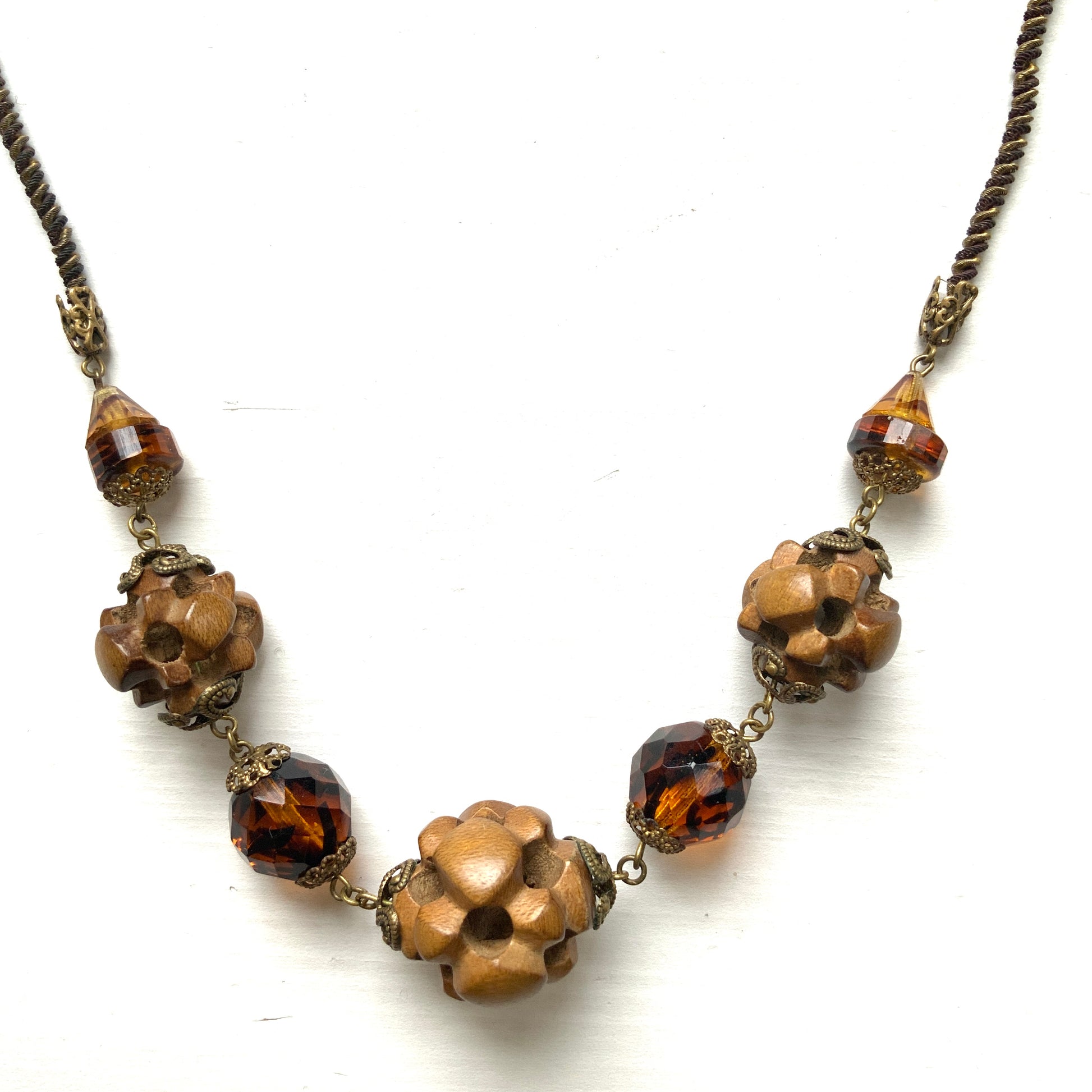 A striking necklace featuring unique wood beads and amber glass. 個性的なウッドビーズとアンバーグラスを組み合わせたネックレス。