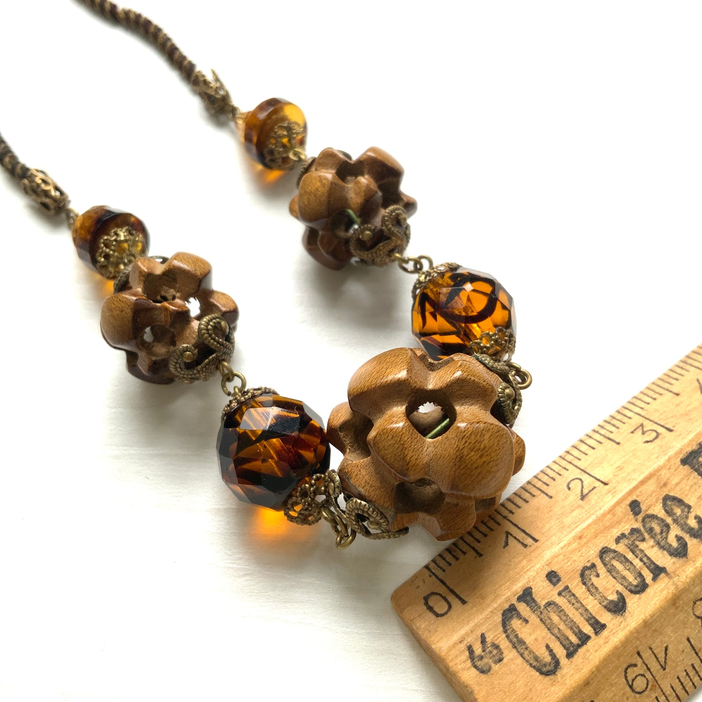 A striking necklace featuring unique wood beads and amber glass. 個性的なウッドビーズとアンバーグラスを組み合わせたネックレス。