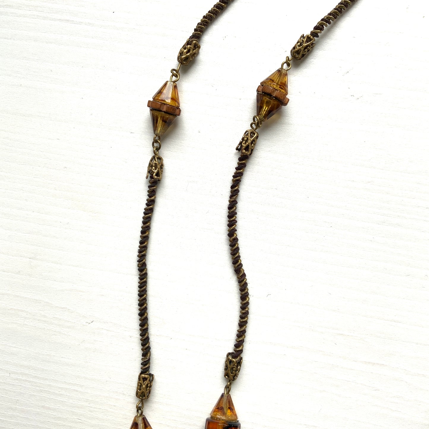 A striking necklace featuring unique wood beads and amber glass. 個性的なウッドビーズとアンバーグラスを組み合わせたネックレス。