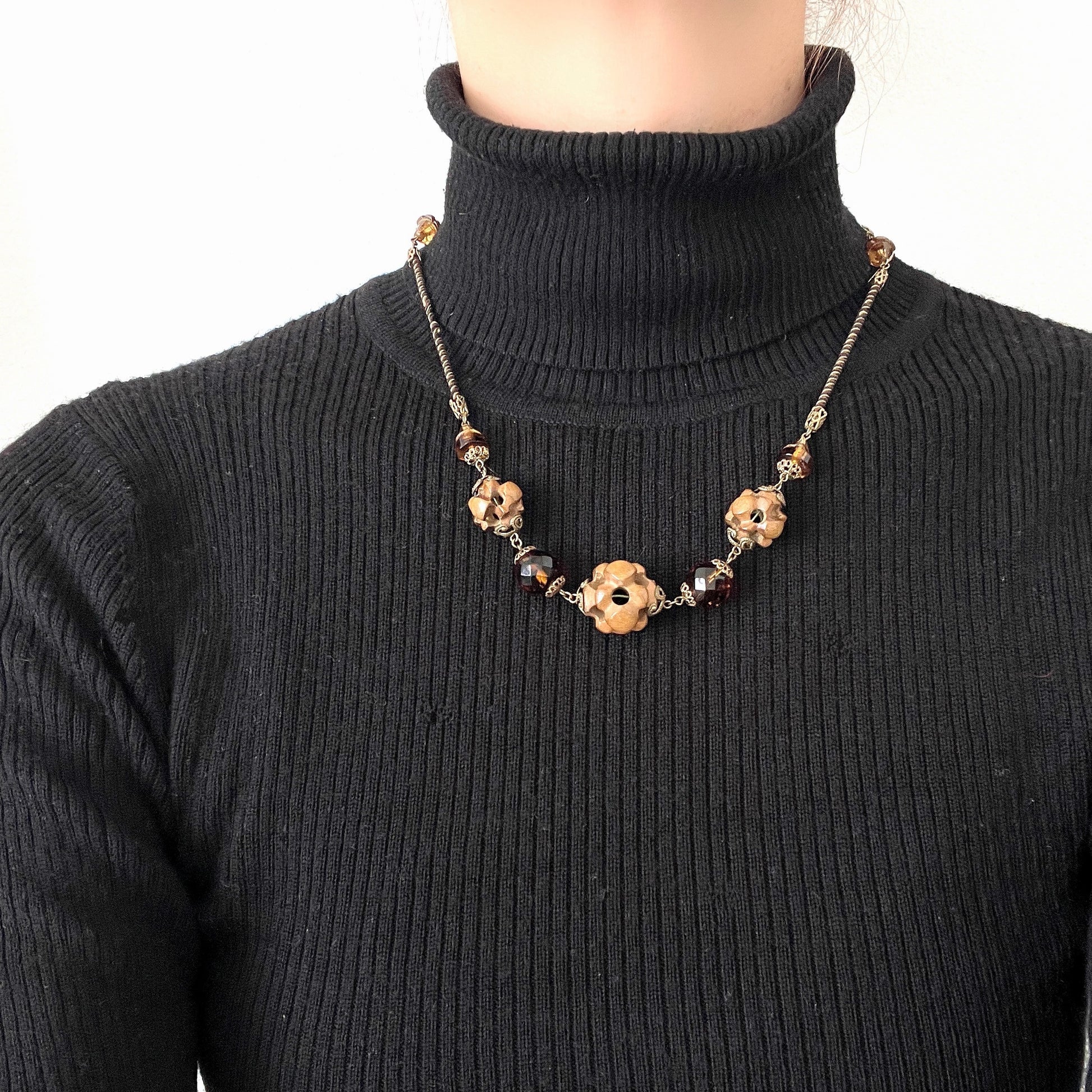 A striking necklace featuring unique wood beads and amber glass. 個性的なウッドビーズとアンバーグラスを組み合わせたネックレス。