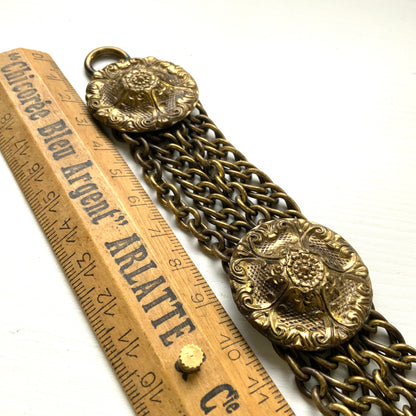 Brass bracelet featuring ornate floral discs linked with multiple chains. フローラルモチーフのメタルディスクと多連チェーンを組み合わせた、ブラス製ブレスレット。 