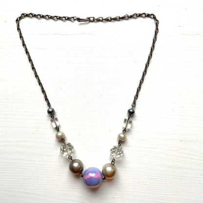 A vintage necklace featuring opalescent glass enclosing pink and violet foil.  ピンクやパープルのフォイルを閉じ込めた、オパルセントガラスのヴィンテージネックレス。