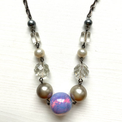 A vintage necklace featuring opalescent glass enclosing pink and violet foil.  ピンクやパープルのフォイルを閉じ込めた、オパルセントガラスのヴィンテージネックレス。