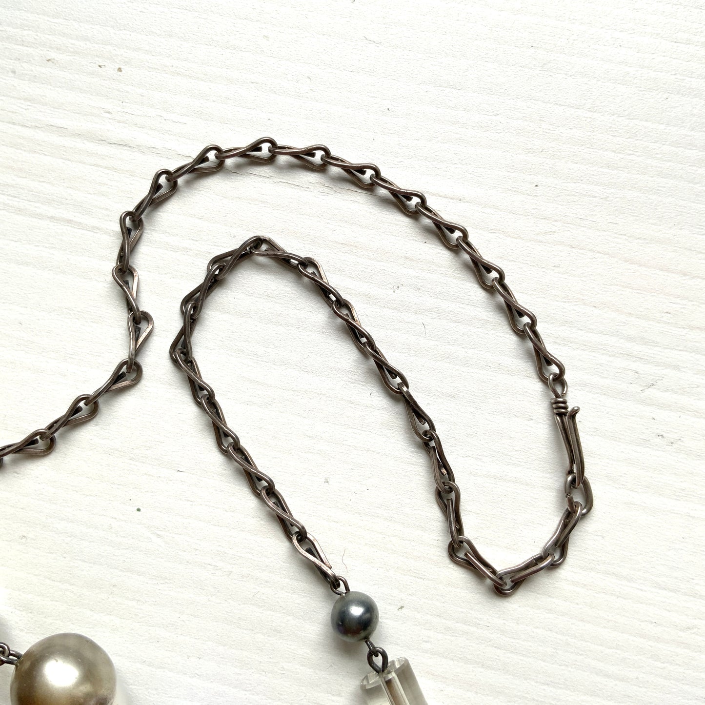 A vintage necklace featuring opalescent glass enclosing pink and violet foil.  ピンクやパープルのフォイルを閉じ込めた、オパルセントガラスのヴィンテージネックレス。