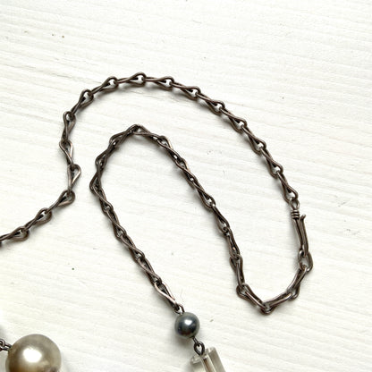 A vintage necklace featuring opalescent glass enclosing pink and violet foil.  ピンクやパープルのフォイルを閉じ込めた、オパルセントガラスのヴィンテージネックレス。