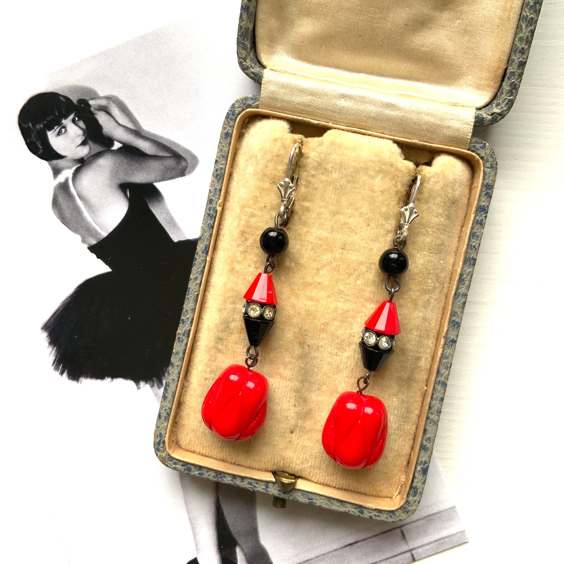 Earrings featuring faceted red and black cone beads, finished with a uniquely shaped red glass drop. ファセットカットの赤と黒のコーンビーズに、ユニークなフォルムのレッドガラスが揺れるピアス。