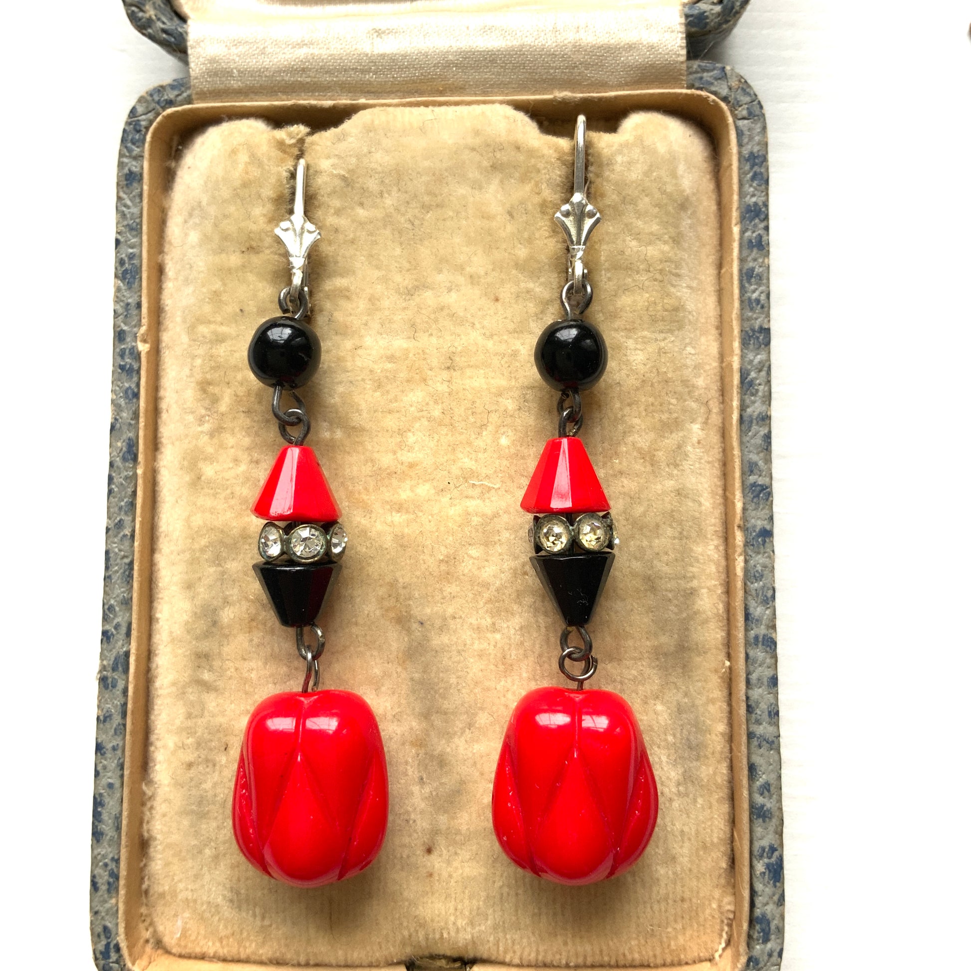 Earrings featuring faceted red and black cone beads, finished with a uniquely shaped red glass drop. ファセットカットの赤と黒のコーンビーズに、ユニークなフォルムのレッドガラスが揺れるピアス。