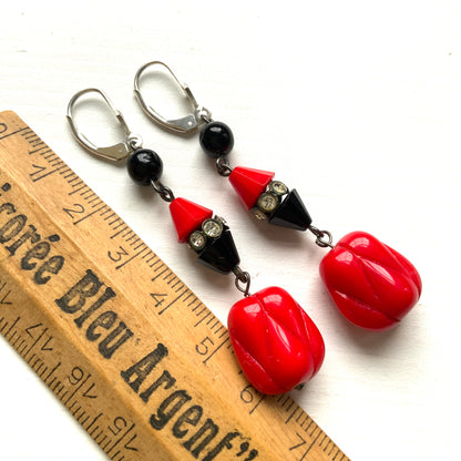 Earrings featuring faceted red and black cone beads, finished with a uniquely shaped red glass drop. ファセットカットの赤と黒のコーンビーズに、ユニークなフォルムのレッドガラスが揺れるピアス。