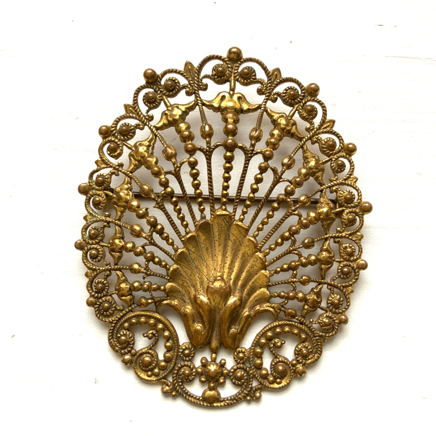 Delicate filigree brooch featuring a fan-like shape with a central shell motif. T 扇のようなフォルムにシェルモチーフをあしらった、繊細なフィリグリーのブローチ。