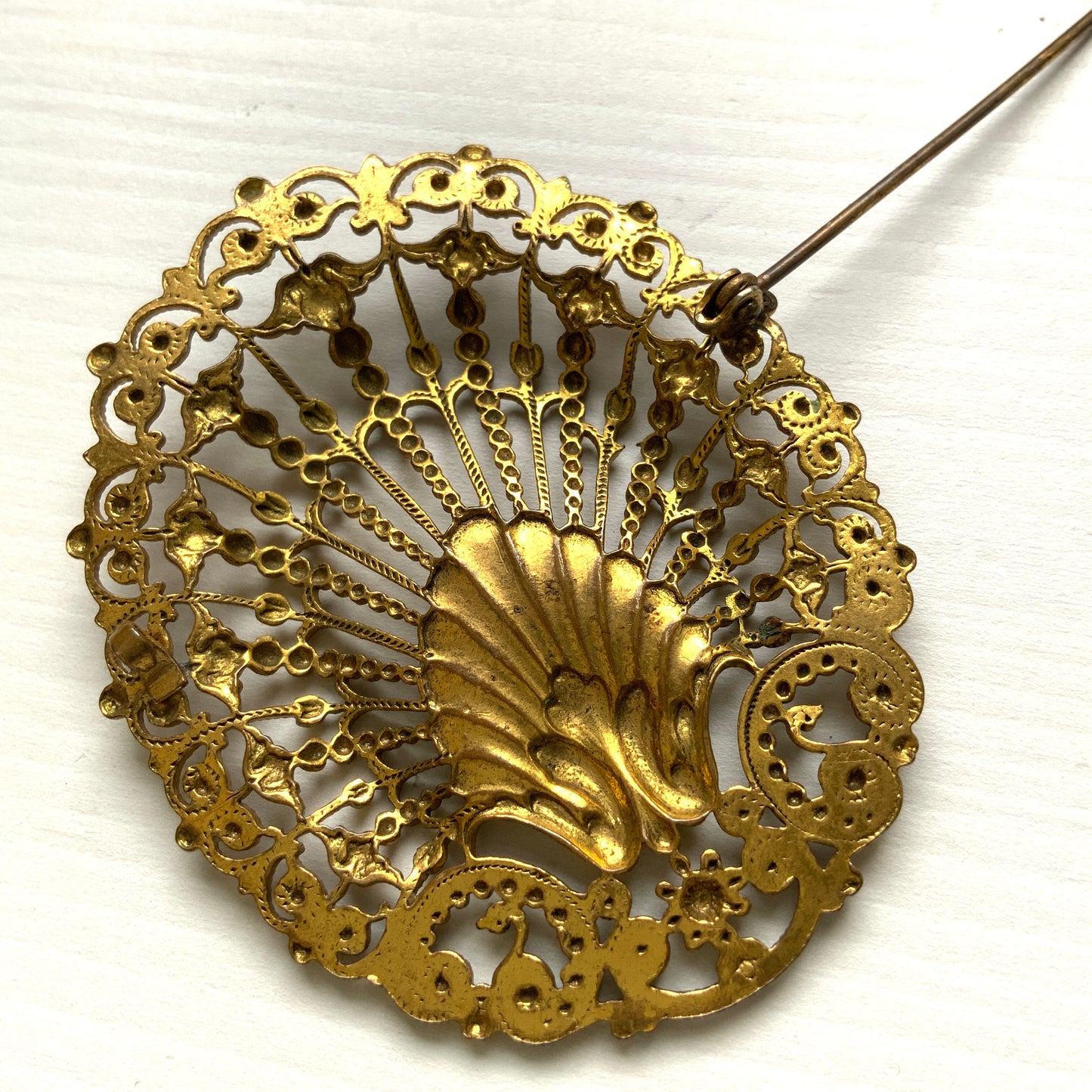Delicate filigree brooch featuring a fan-like shape with a central shell motif. T 扇のようなフォルムにシェルモチーフをあしらった、繊細なフィリグリーのブローチ。