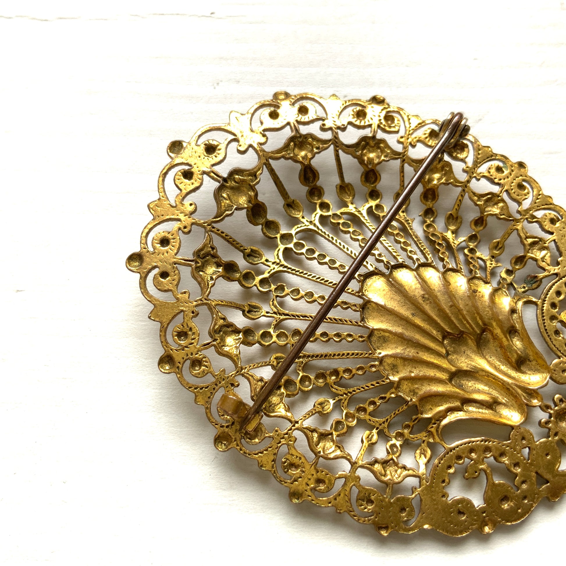 Delicate filigree brooch featuring a fan-like shape with a central shell motif. T 扇のようなフォルムにシェルモチーフをあしらった、繊細なフィリグリーのブローチ。
