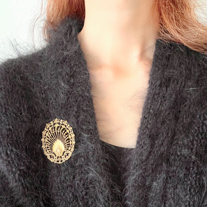 Delicate filigree brooch featuring a fan-like shape with a central shell motif. T 扇のようなフォルムにシェルモチーフをあしらった、繊細なフィリグリーのブローチ。