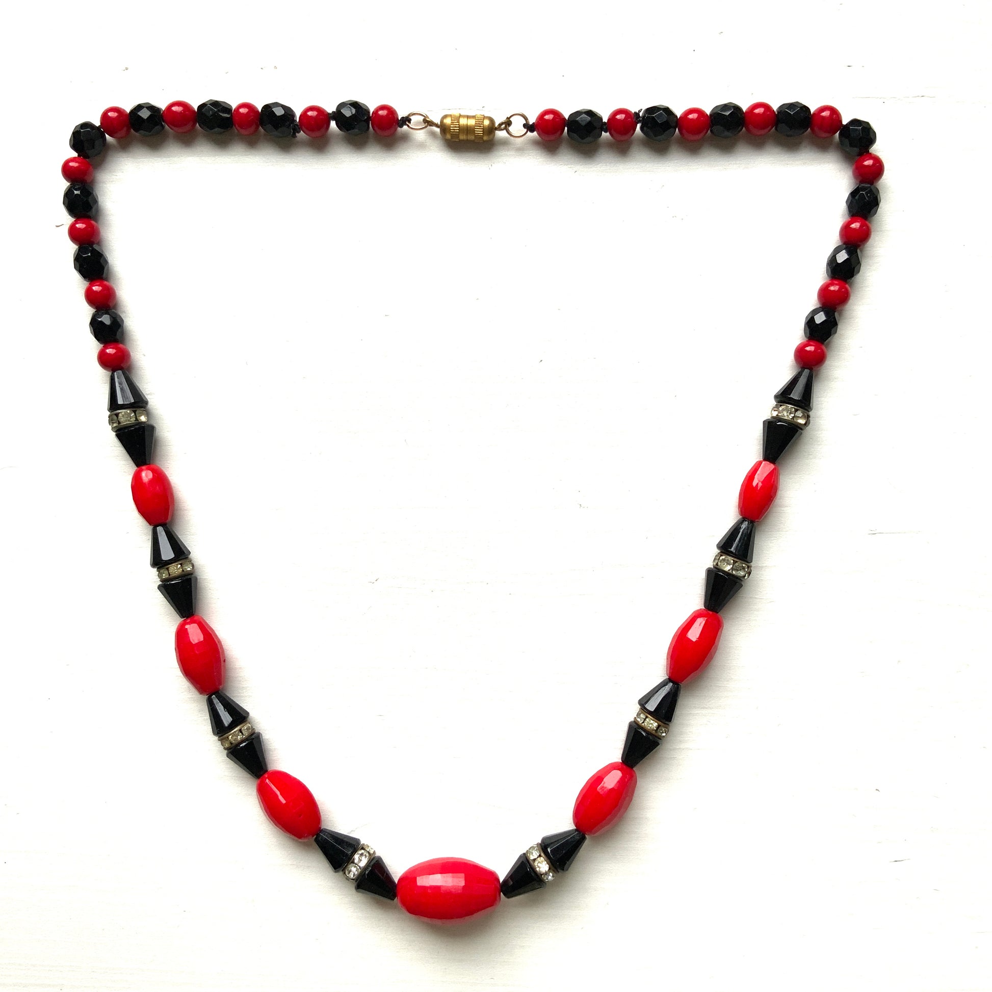 A striking 1930s necklace crafted from red and black glass. 赤と黒のガラスを組み合わせた、1930年代のネックレス。