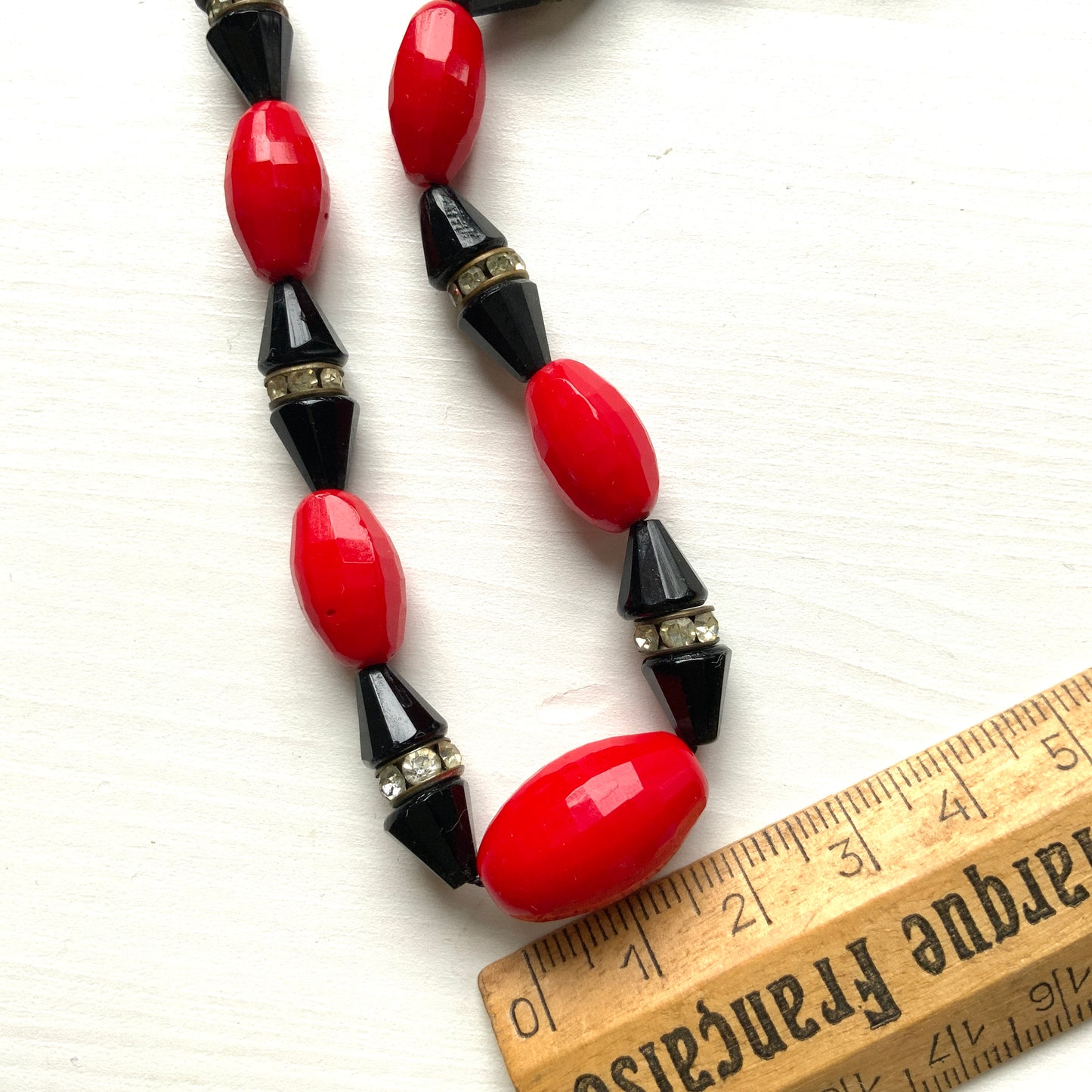 A striking 1930s necklace crafted from red and black glass. 赤と黒のガラスを組み合わせた、1930年代のネックレス。