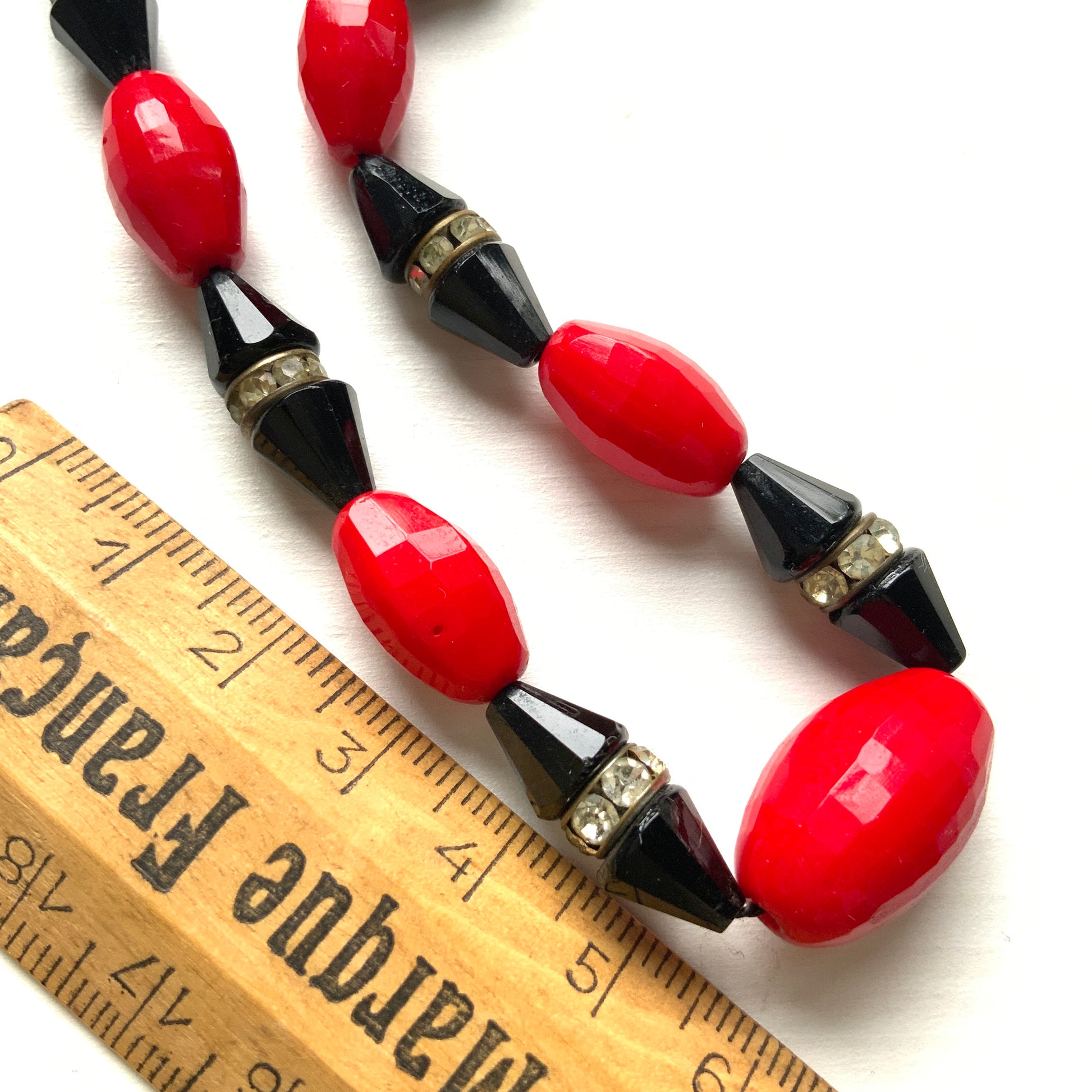 A striking 1930s necklace crafted from red and black glass. 赤と黒のガラスを組み合わせた、1930年代のネックレス。