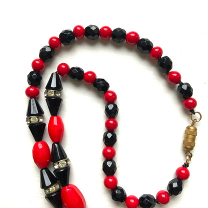 A striking 1930s necklace crafted from red and black glass. 赤と黒のガラスを組み合わせた、1930年代のネックレス。
