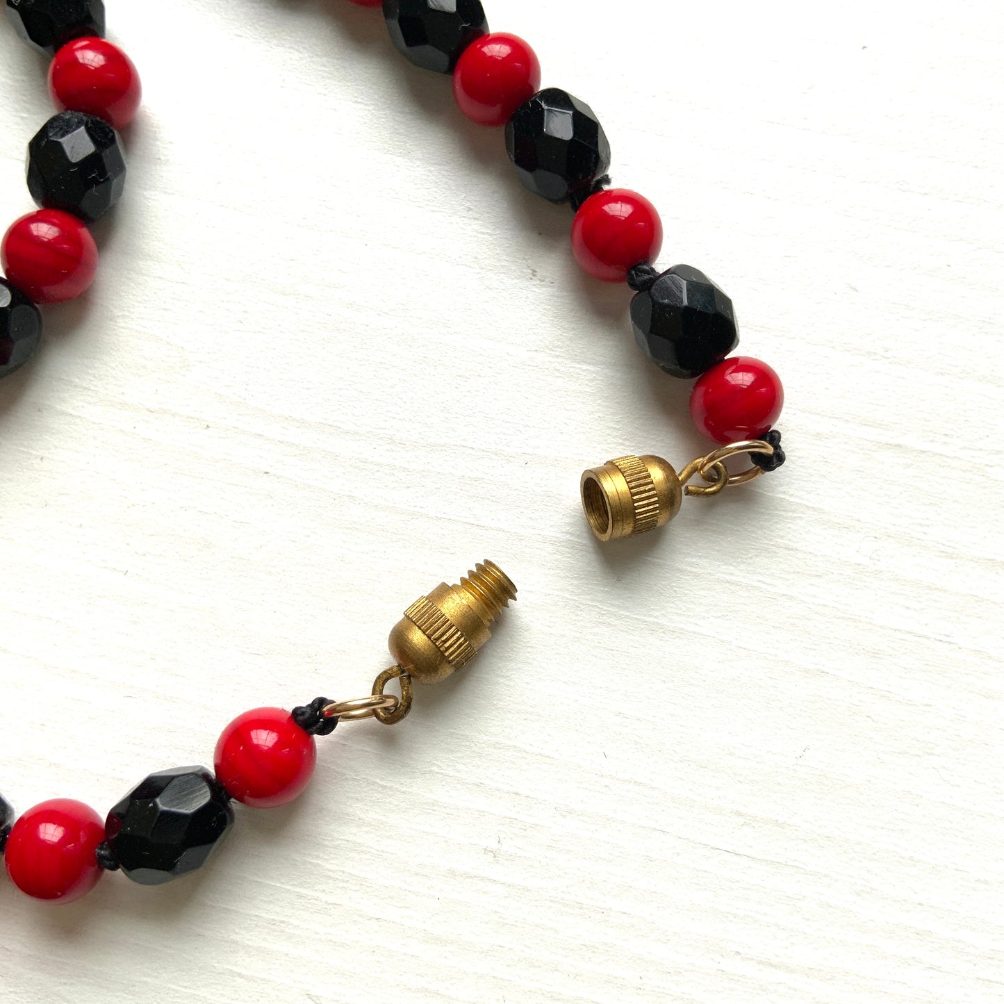 A striking 1930s necklace crafted from red and black glass. 赤と黒のガラスを組み合わせた、1930年代のネックレス。