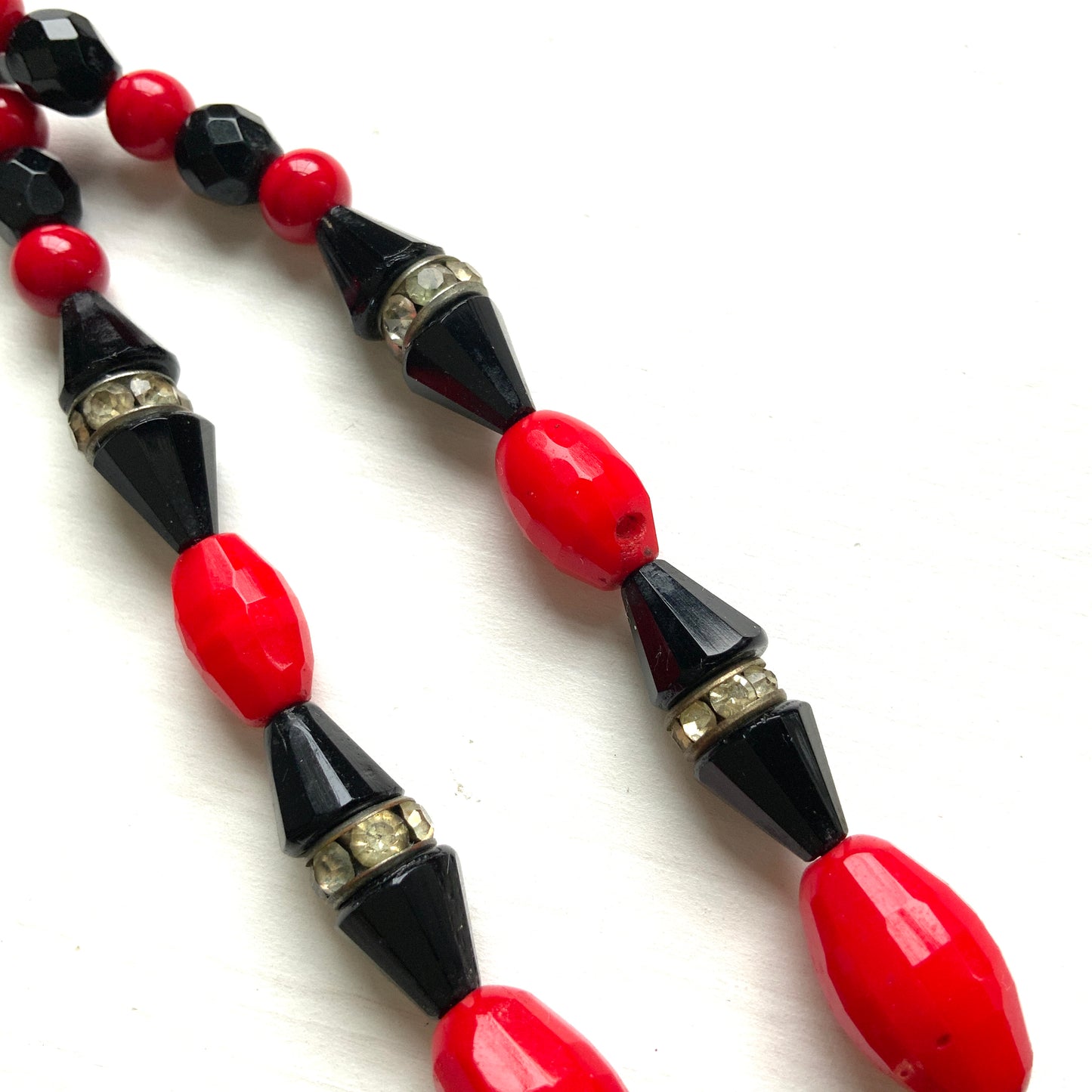 A striking 1930s necklace crafted from red and black glass. 赤と黒のガラスを組み合わせた、1930年代のネックレス。