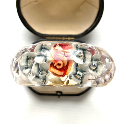 A vintage lucite bangle featuring carved and painted rose intaglios. クリアルーサイトに薔薇のインタリオが施されたヴィンテージバングル。