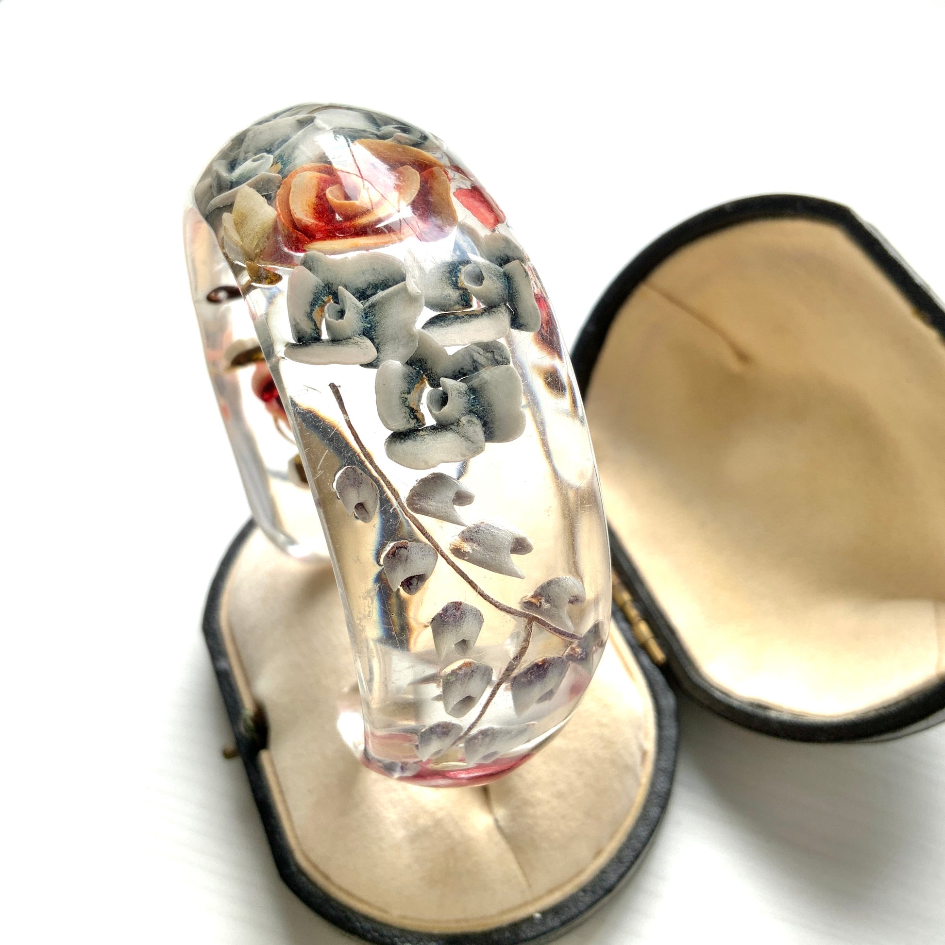 A vintage lucite bangle featuring carved and painted rose intaglios. クリアルーサイトに薔薇のインタリオが施されたヴィンテージバングル。